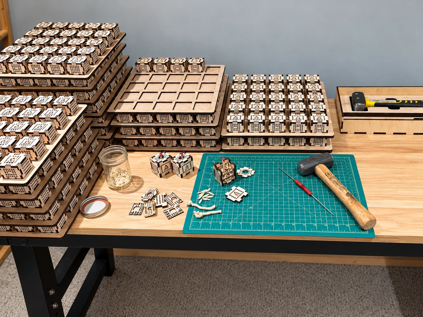 BurnBloc fire starter cubes and assembly tools arranged on trays at a workshop workbench
